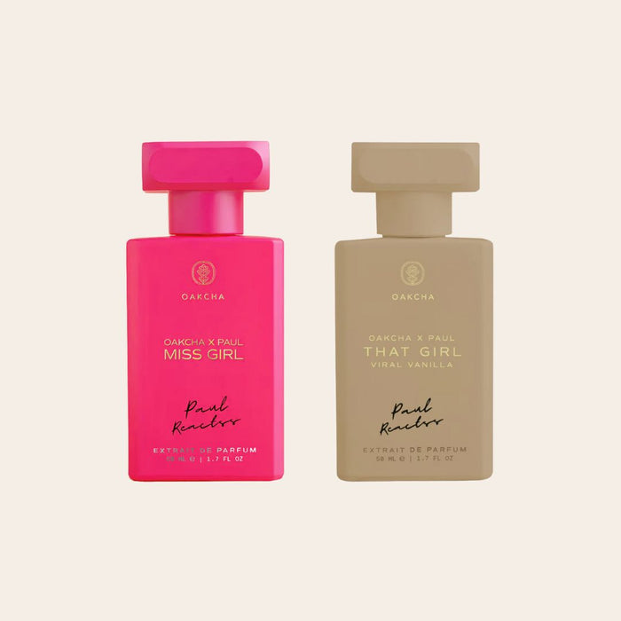 Front of Paul Reactss - The Girls showing two extrait bottles Miss Girl hot pink and That Girl beige on pale pink backdrop