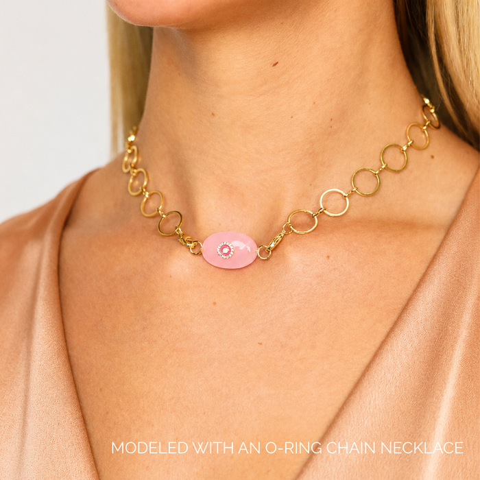 Rose Quartz Eye Charm showcased on a gold O-ring chain necklace, highlighting its elegance and protective symbolism.