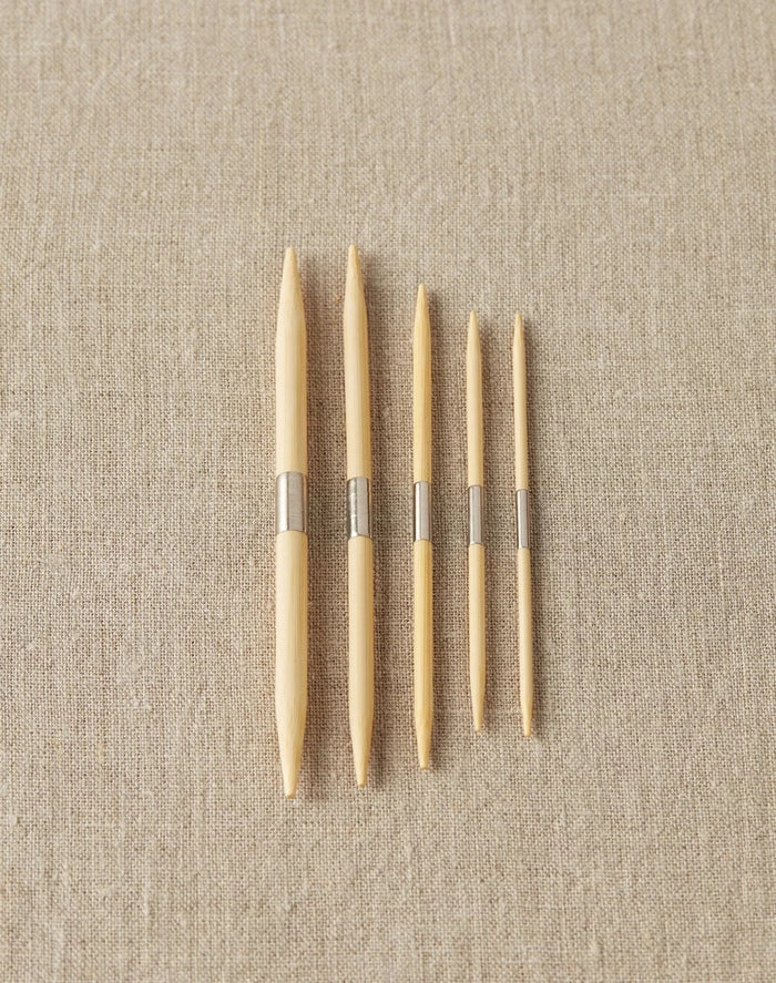 Bamboo cable needles with nickle-plated steel band in the center to use on a magnetic surface to keep them in reach.