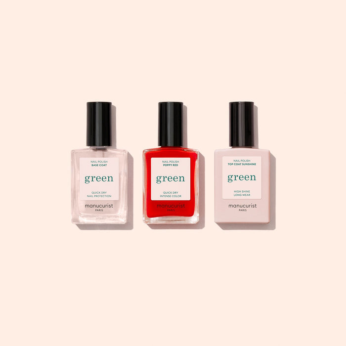 The Manucurist Basic Kit is shown with three bottles side by side on a light beige background. Ideal for gel-effect manicures, the set features a base coat, bright red polish, and top coat—all with sleek black caps.