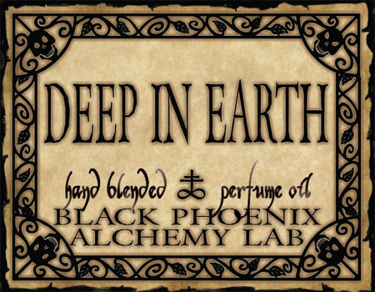 Label for 'Deep in Earth' hand blended perfume oil by Black Phoenix Alchemy Lab with decorative border.