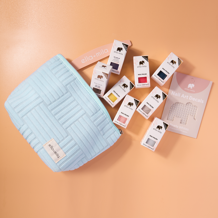 Ella's Essentials light blue quilted pouch with polishes, decals and cuticle oil spilling out
