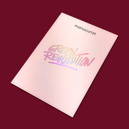 A pale pink booklet on a dark red background highlights the Manucurist US Gift Card, with holographic "GREEN REVOLUTION" text—an inspiring choice for green gifting.