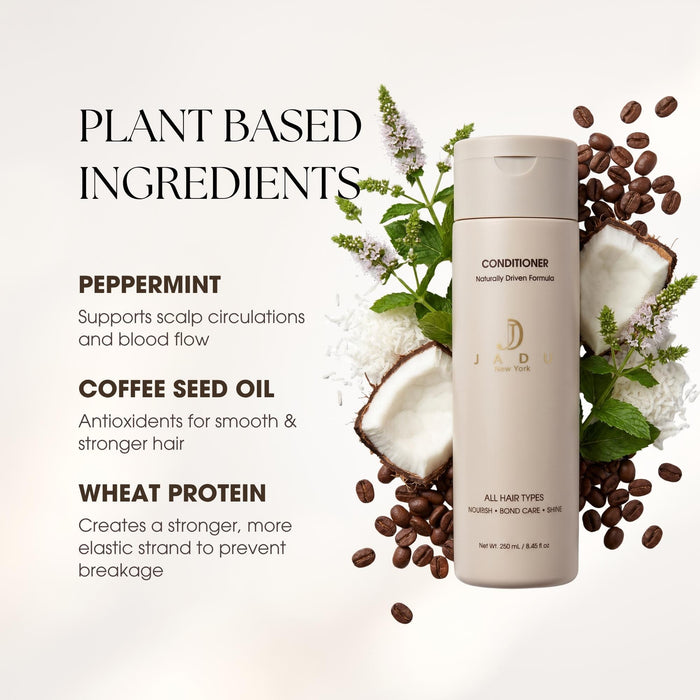 A bottle of Jadu All natural Conditioner stands on a light beige background surrounded by styled ingredients: coffee beans, sliced coconut, mint leaves, and small white flowers. Text on the left reads 'PLANT BASED INGREDIENTS' with bullet points for peppermint, coffee seed oil, and wheat protein.