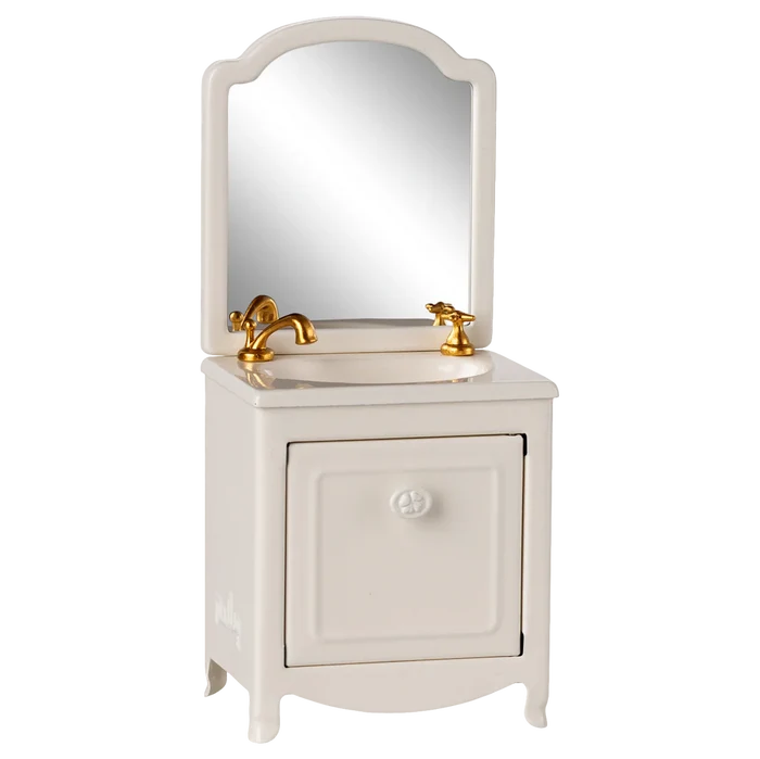 White vanity with mirror and gold fixtures on a white background