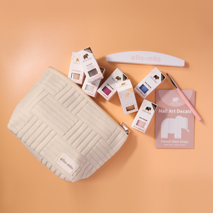 Mila's Must-Haves cream quilted pouch with polishes, decals and nail file spilling out