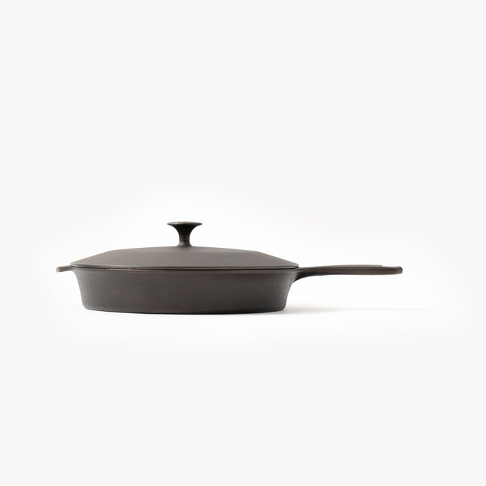 Side view of the No.10 Cast Iron Skillet Lid with pointed knob resting on a Field Skillet