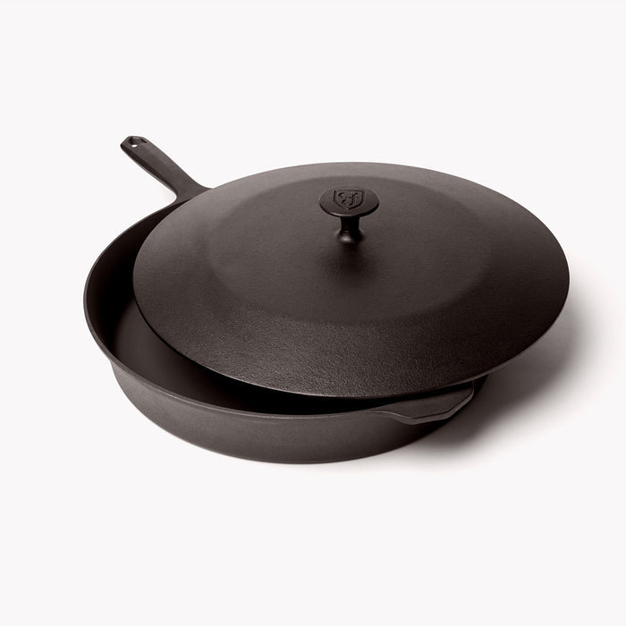 Cast iron lid resting slightly offset on the No.12 Field Skillet, angled view