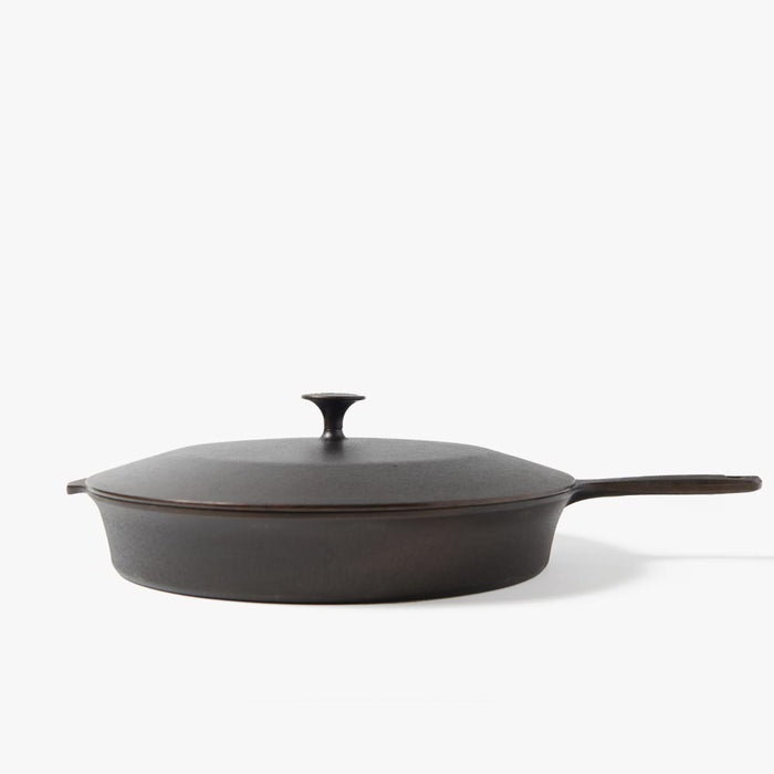 Side view of the No.12 Cast Iron Skillet Lid with pointed knob resting on a Field Skillet