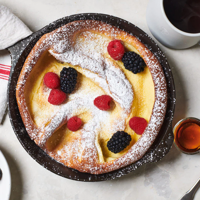 Dutch baby topped with berries and powdered sugar in the No.6 Field Cast Iron Skillet