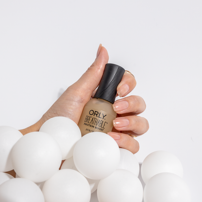 Hand holding an ORLY Breathable protein boost bottle