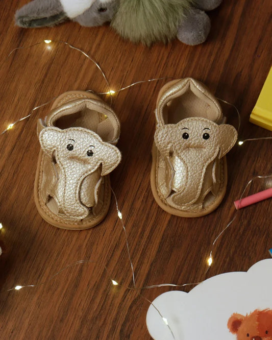 Toddler elephant sandals with cream fabric uppers, tan trim, hook-and-loop strap