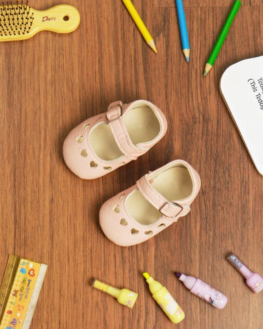 Light pink toddler sandals with heart cutouts and two hook-and-loop straps