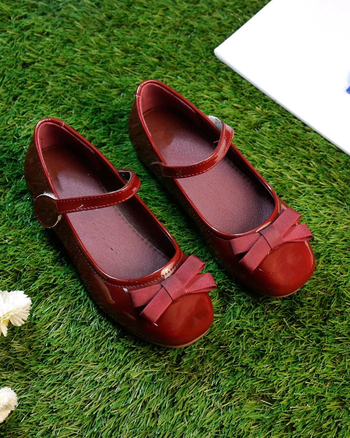 Red girls' Mary Jane sandals with bow accents and buckle straps