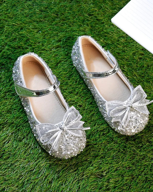 Girls’ silver glitter sandals with bow accents and metallic strap, slip-on style