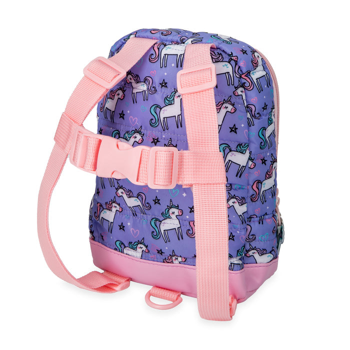 The Quilted Backpack with Safety Harness is a small purple toddler backpack with pink straps, unicorn, heart, and star designs. It features a chest clip and a pink loop at the bottom for added safety.