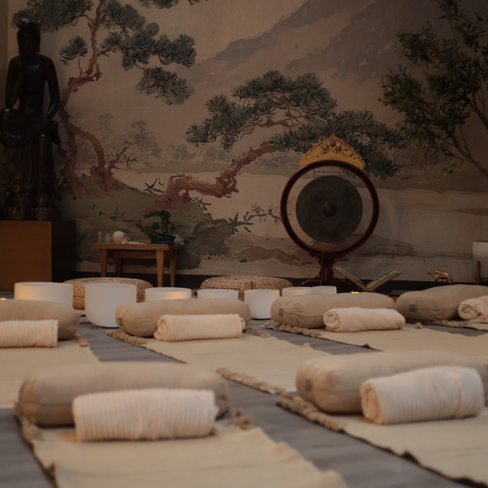 A serene space for SOMATIC BREATHWORK + CRYSTAL SOUND HEALING featuring cushions, calming decor, and ambient lighting.