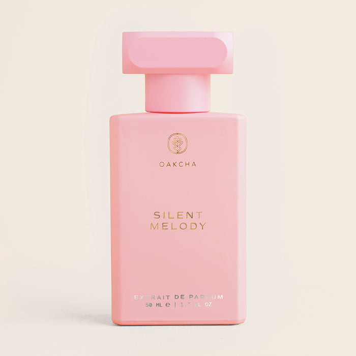 Front view of Silent Melody perfume bottle showcasing rectangular matte pink bottle with T-shaped cap on pale cream background