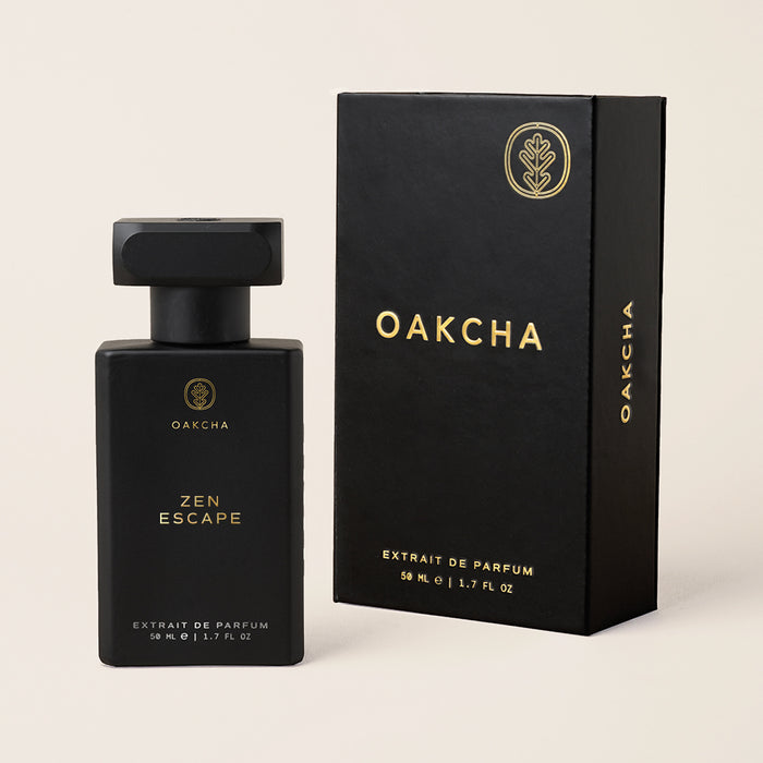 Front view of Zen Escape extrait de parfum bottle and box showcasing matte black rectangular packaging with gold Oakcha logo on a light beige background