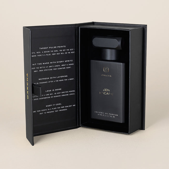 Front view of Zen Escape Extrait de Parfum bottle in an open black presentation box showcasing the boxed gift packaging on a beige background